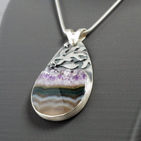Silver pendant with Amethyst in Quartz cabochon, silver falling star above stone, close-up