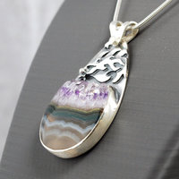 Silver pendant with Amethyst in Quartz cabochon, silver falling star above stone, close-up
