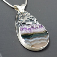 Silver pendant with Amethyst in Quartz cabochon, silver falling star above stone, close-up