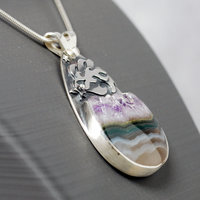 Silver pendant with Amethyst in Quartz cabochon, silver falling star above stone, close-up