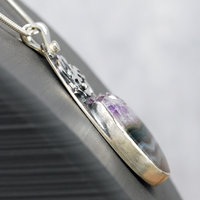 Silver pendant with Amethyst in Quartz cabochon, silver falling star above stone, close-up