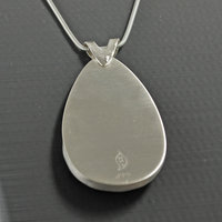 Silver pendant with Amethyst in Quartz cabochon, silver falling star above stone, close-up