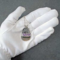 Silver pendant with Amethyst in Quartz cabochon, silver falling star above stone, in hand