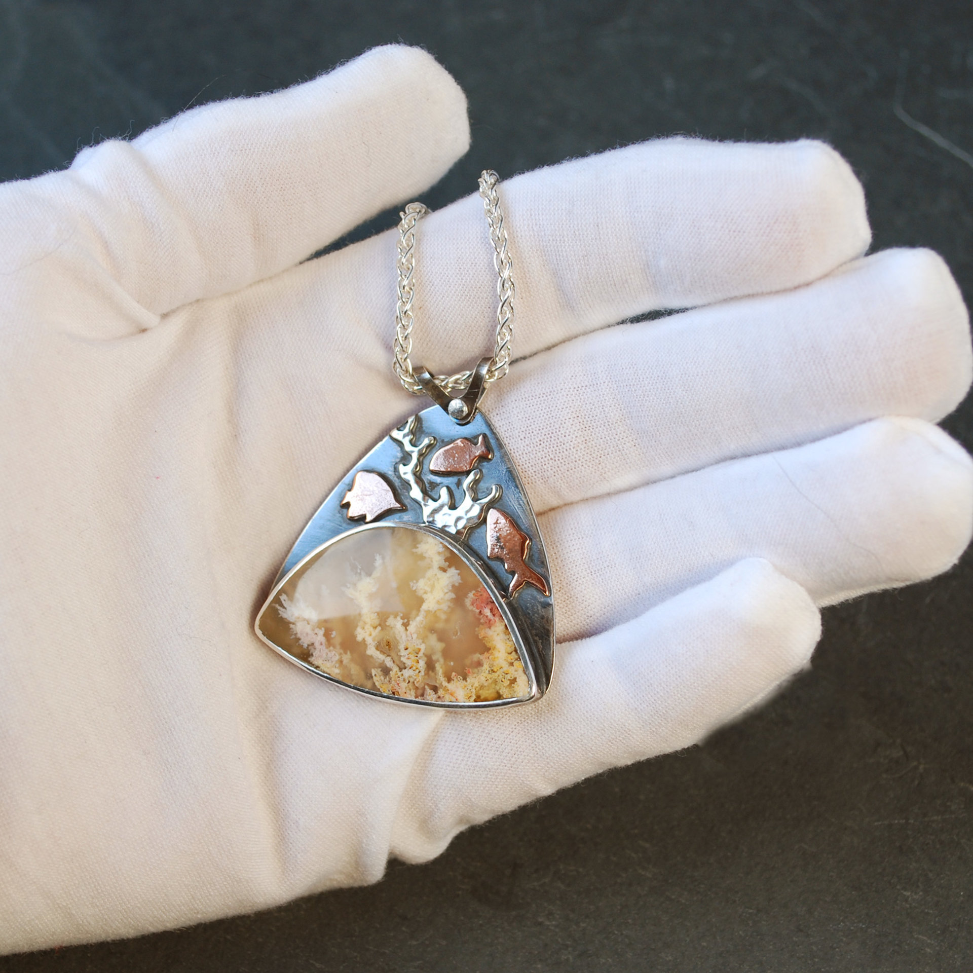 Regency Rose plume agate pendant in hand