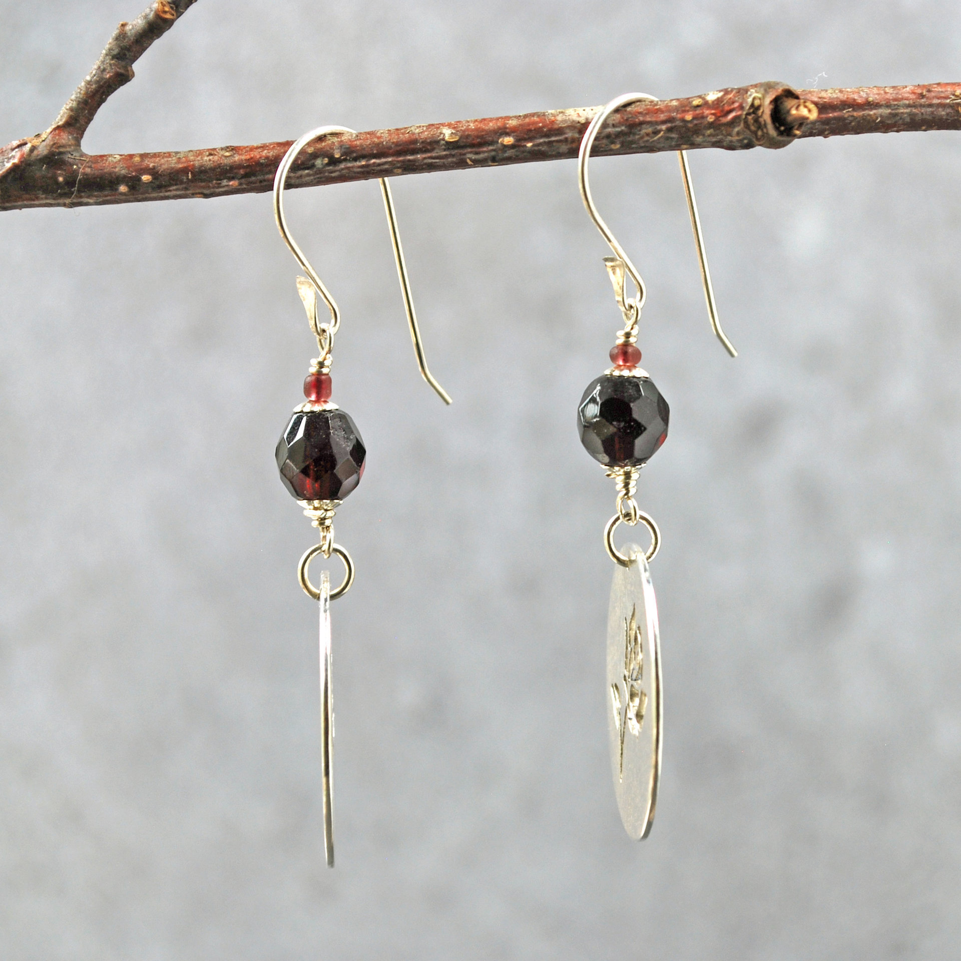Silver Rose cut-out garnet earrings, hanging side view