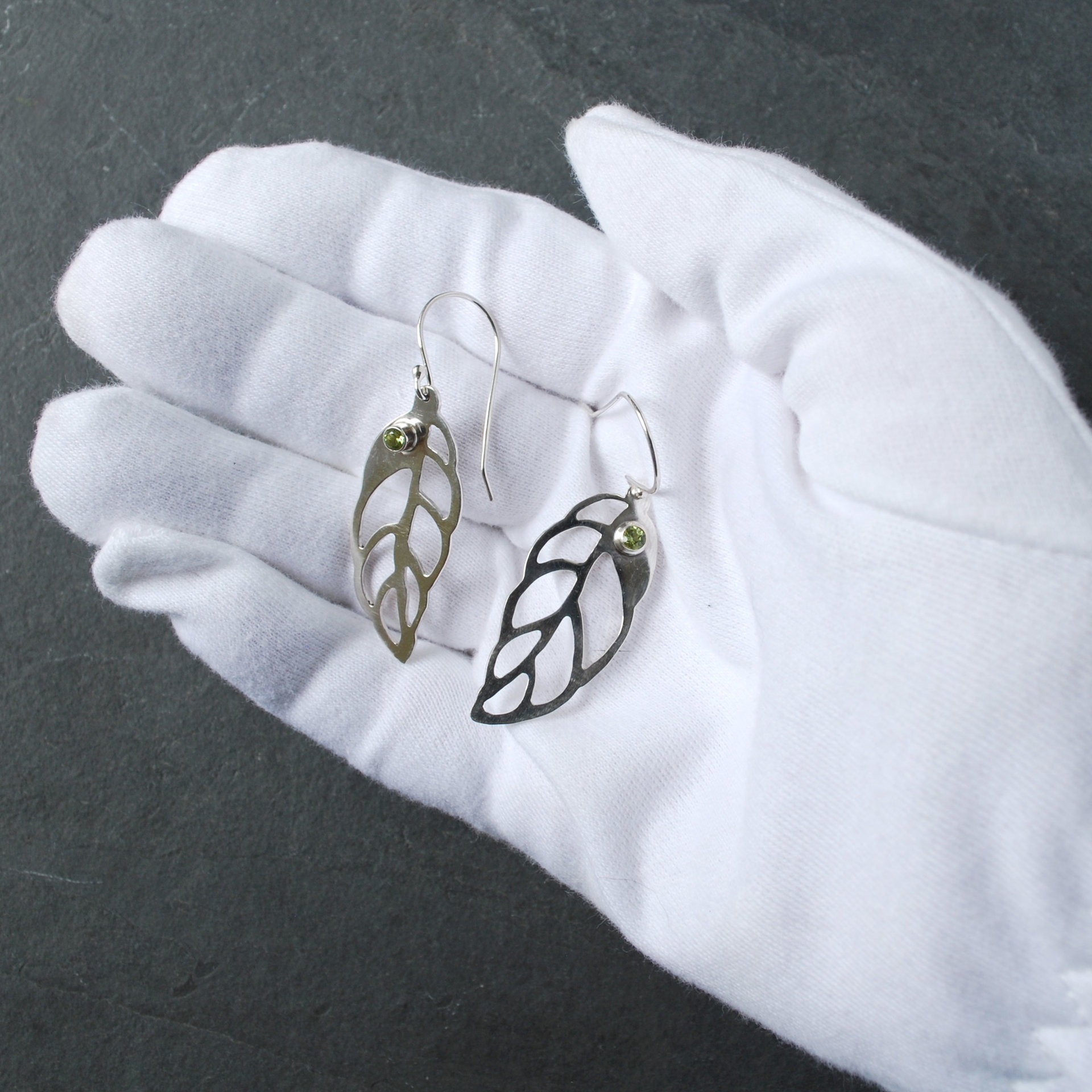 Silver Leaf Earrings with Peridot in  hand